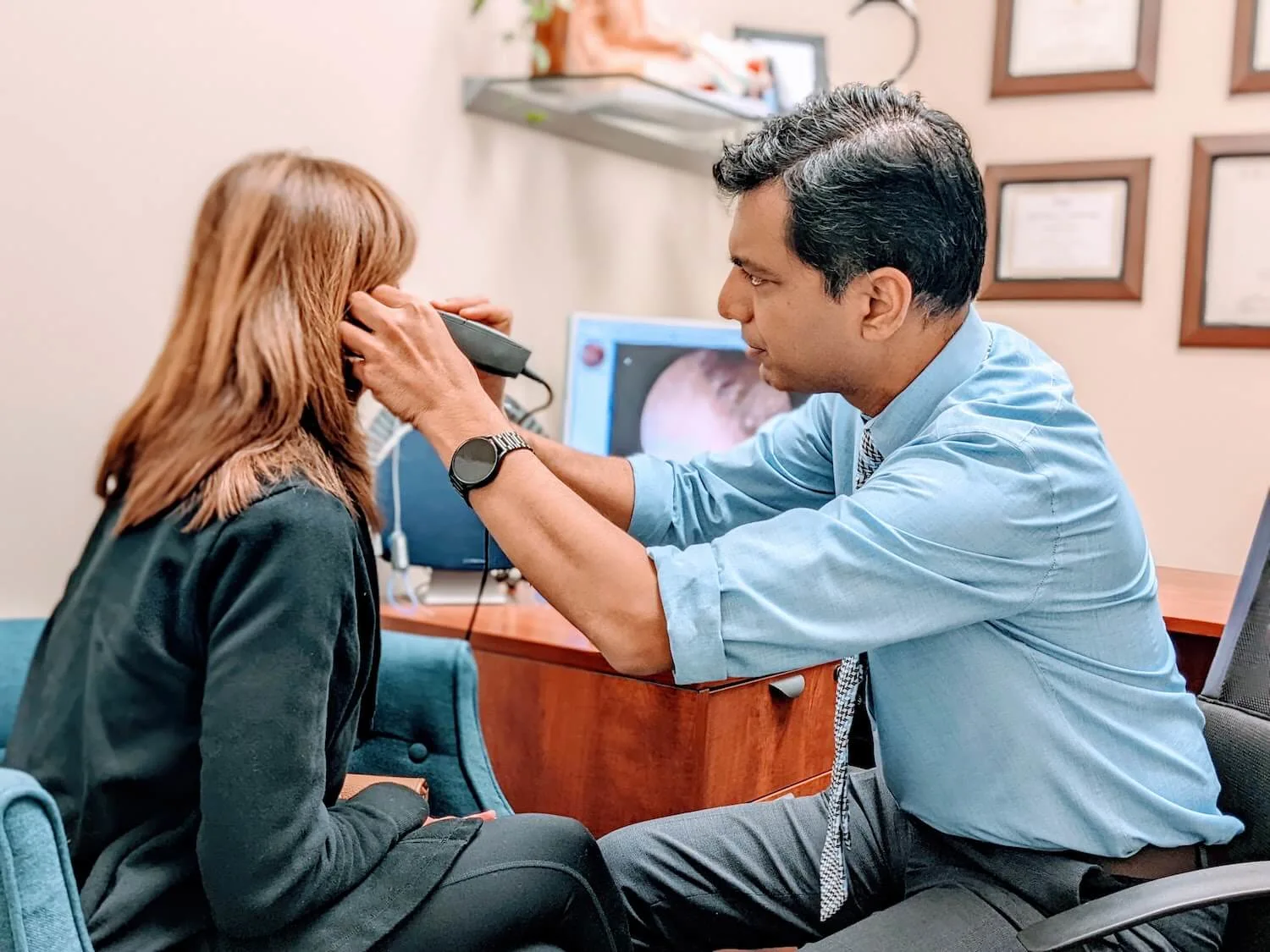 Audiologist performing ear exam during hearing evaluation